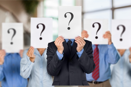 Business people with question marks on face on backgroundの写真素材