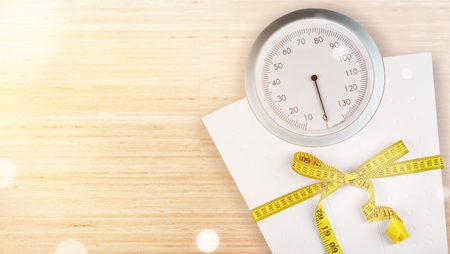 Bathroom scale with a measuring tape on backgroundの写真素材