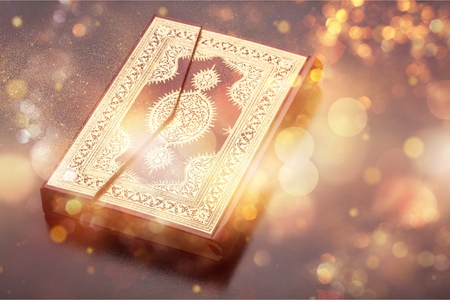 Islamic Holy Book Quran Under Soft Light on Black Background