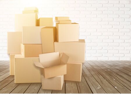 Different cardboard boxes in room on wooden floor