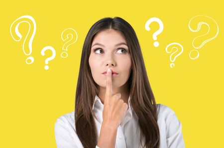 Many questions. Diligent serious student putting her hands up and thinking about her life after graduation from the universityの写真素材