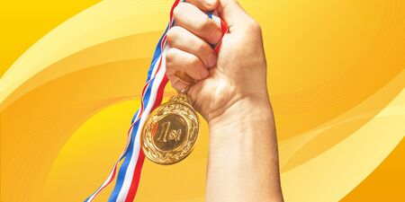 Gold medal with ribbon in hand onの写真素材