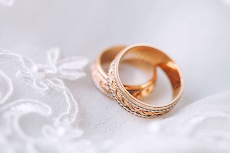 Designer wedding rings in the corner on a sparkling glitter background in panoramic banner format with copy space and selective focusの写真素材