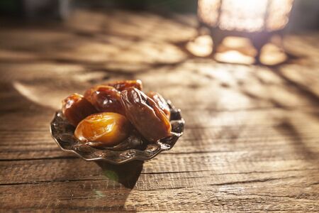 Dates in wooden bowl and Arabian lanternの写真素材