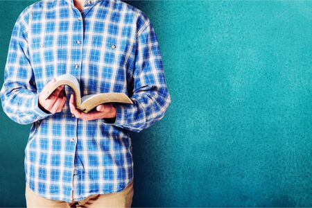 Man reading old heavy book on background