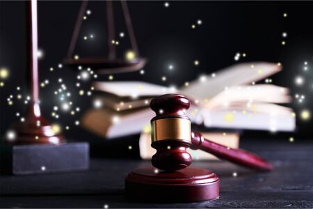 Justice Scales, books and gavel on dark background
