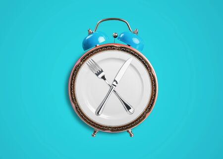 Alarm clock and plate with cutlery .