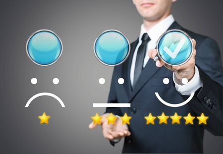 Businessman pressing smiley face emoticonの写真素材