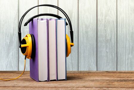 Yellow headphones with stack book on wooden tableの写真素材