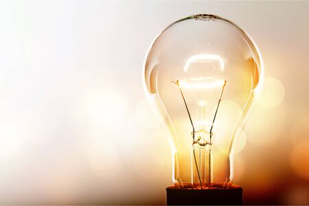 Glowing glass light bulb on backgroundの写真素材