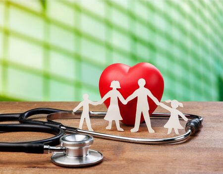 Medical Insurance Concept With Family Cut-out And Stethoscope On Wooden Deskの写真素材