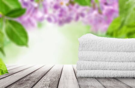 Pile of fluffy towels and flowerの写真素材