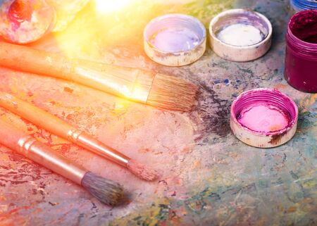 Artist paints a picture of oil paint brush in hand with palette closeupの写真素材