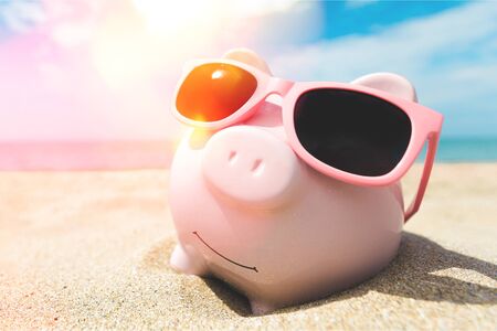Piggy Bank Wearing Sunglasses Relaxing At The Beachの写真素材