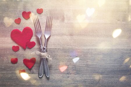 Restaurant series. Valentines day dinner with table setting in rustic wood style with cutleryの写真素材