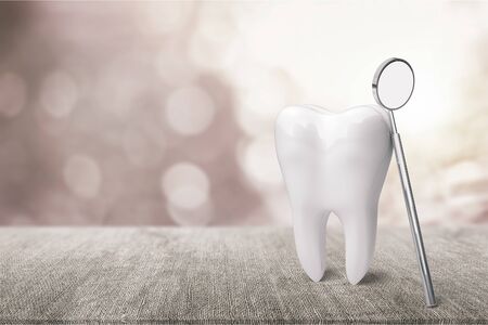 Big tooth and dentist mirror in dentist clinic on background