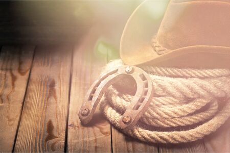 Metal horseshoe and cowboy hat on wooden tableの写真素材