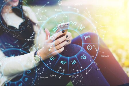 Astrology smartphone app concept, woman using mobile phone, close up of hands
    
    - Image