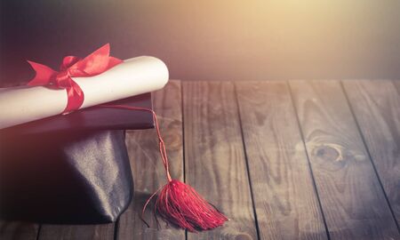 Graduation cap and diploma on  background