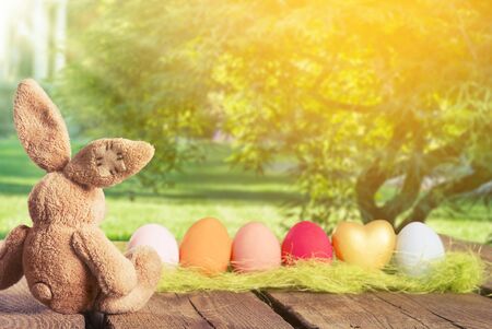 Painted Easter eggs in a basket on the table with a congratulatory textの写真素材