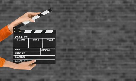 Women hands holding clapper board for making video cinema in studio.Movie production clapper board...
