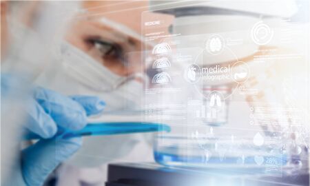 Female scientist in mask and glasses working with microscope
