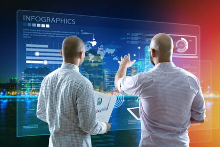 Two business people standing with back and working together with virtual screen