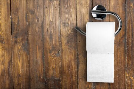 Roll of white toilet paper on metal paper holderの写真素材