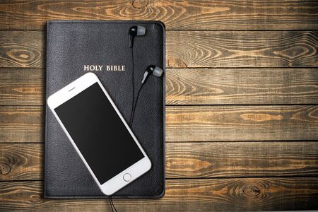 Contemporary image of a Bible with headphones and mobile phone.の写真素材