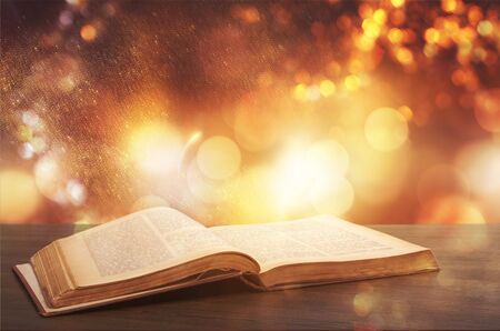 Open antique book over wooden deskの写真素材