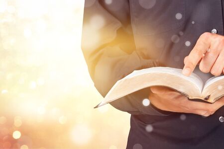 Man reading old heavy book on background