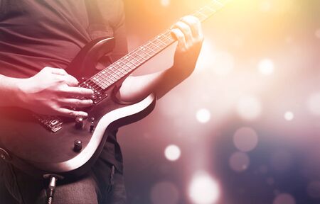 Guitarist on stage for background, soft and blur concept. Close up hand playing guitar. young...