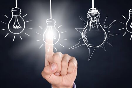 Businessman touching light bulbsの写真素材