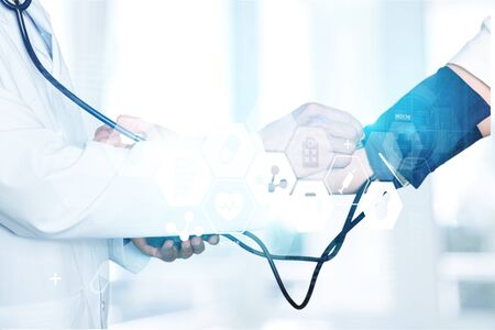 Doctor checking blood pressure of patient , partial view