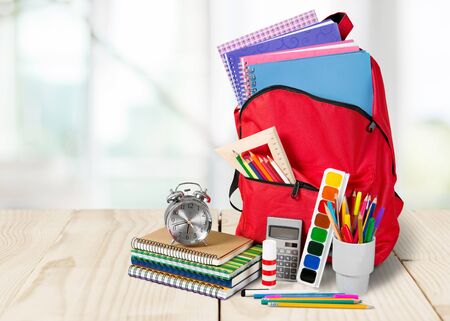 Colorful school supplies in backpack on wooden backgroundの写真素材