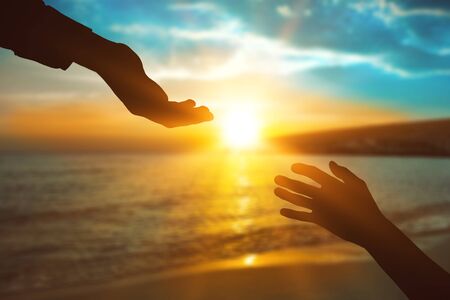 Help hand on sunset backgroundの写真素材