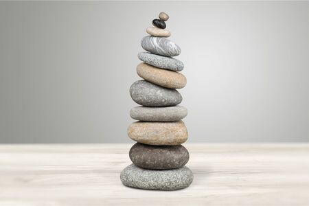 Stone cairn on striped grey white background, five stones tower, simple poise stones, simplicity harmony and balance, rock zen sculpturesの写真素材