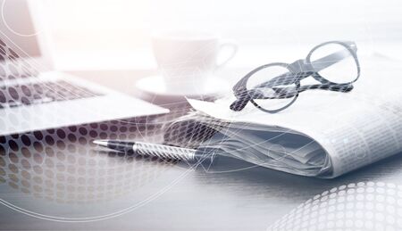 Newspaper with computer on tableの写真素材