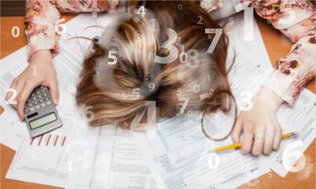 Woman exhausted from doing taxesの写真素材