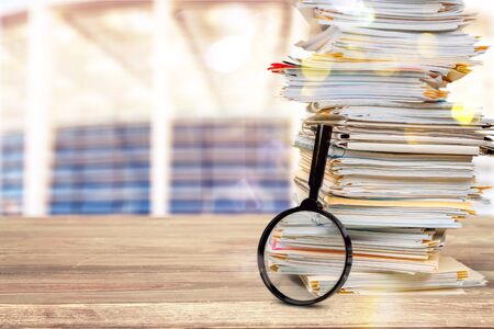 File folders with documents and magnifying glass on backgroundの写真素材