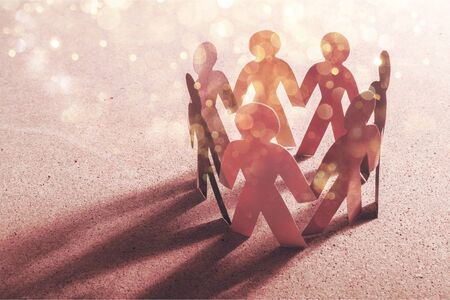 Circle of paper people on paper backgroundの写真素材