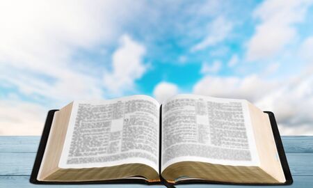 Open book on old wooden table.