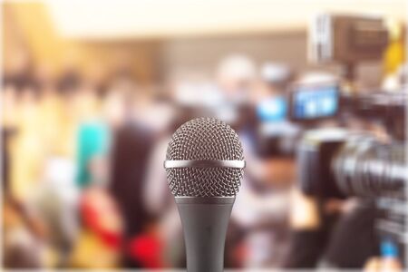 Microphone over the Abstract blurred photo of conference hall or seminar room with attendee background,Small Business training concept,Public speakingの写真素材