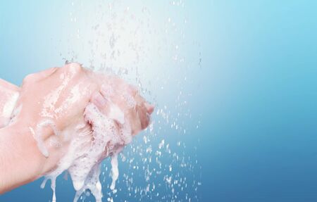 Man washing hands in clean water on blue background