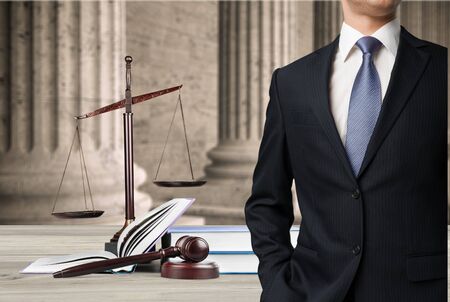 Lawyer standing near Scales of Justice on the background
