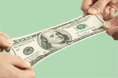 Hands holding one hundred dollars banknote over backgroundの写真素材