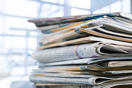 Pile of printed newspapers on white backgroundの写真素材