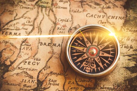 Antique bronze emblem compass, mini compass necklace pendant and binocular telescopes on ancient world map. (vintage style)の写真素材
