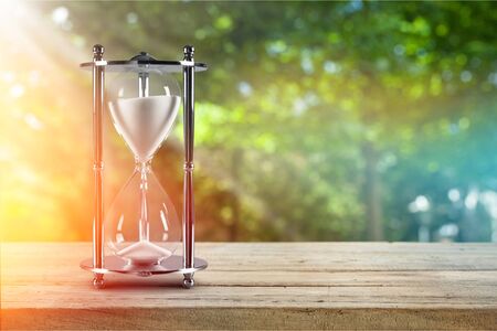 Hourglass in the grass time during sunset.の写真素材