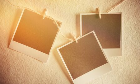 Three vintage blank photos hanging on ropeの写真素材
